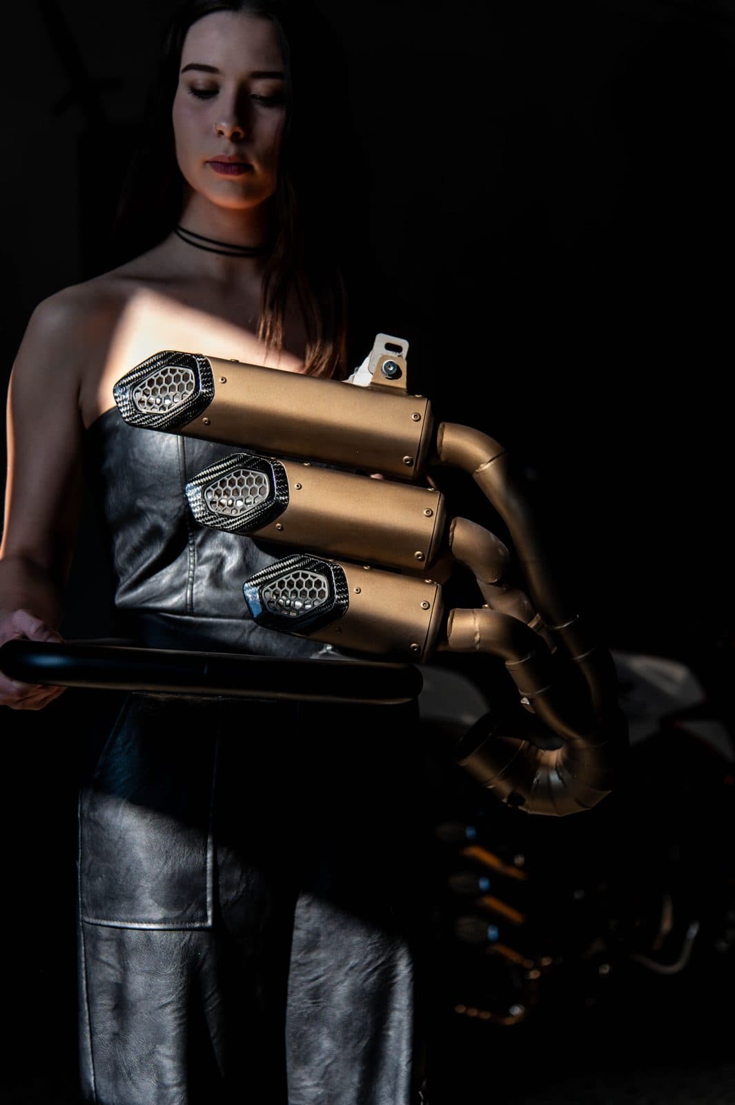 Scarico tre canne bronzo fotografato in studio su fondo scuro